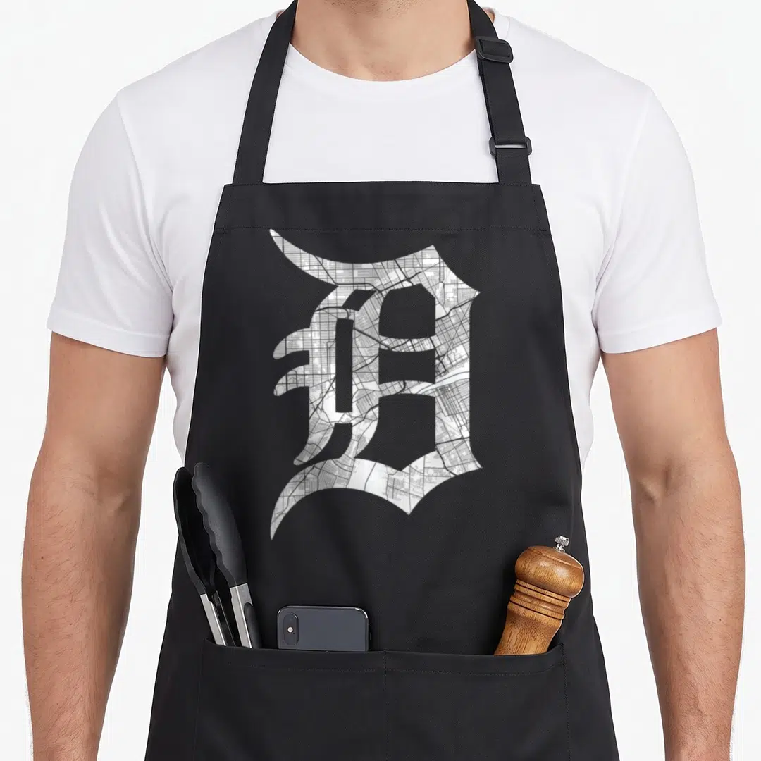 Letter road apron - Gothic letter D filled with detailed city street map in white grey and black — shown on a black cotton canvas apron against a white background