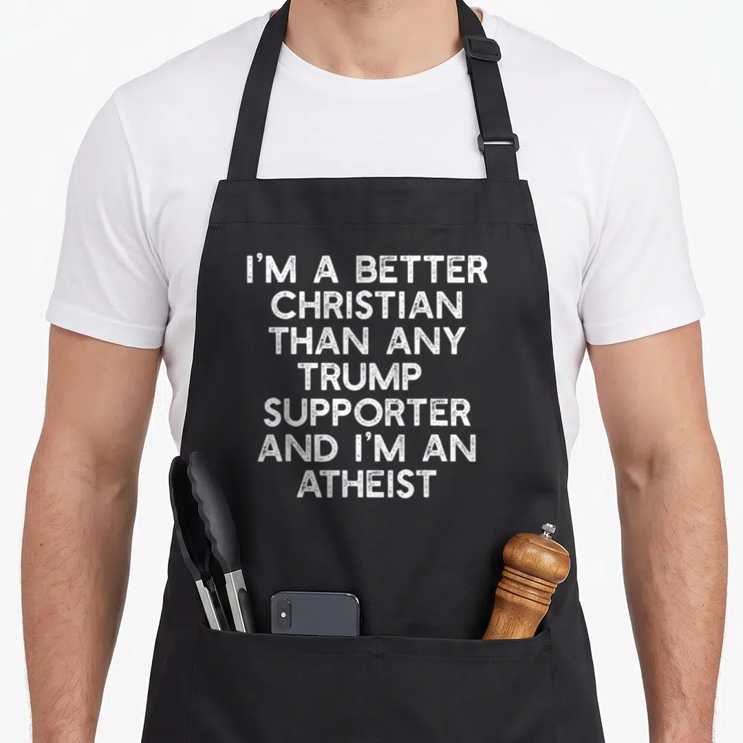 Better meme apron - White stacked text reading I'M A BETTER CHRISTIAN THAN ANY TRUMP SUPPORTER AND I'M AN ATHEIST — shown on a black cotton canvas apron against a white background