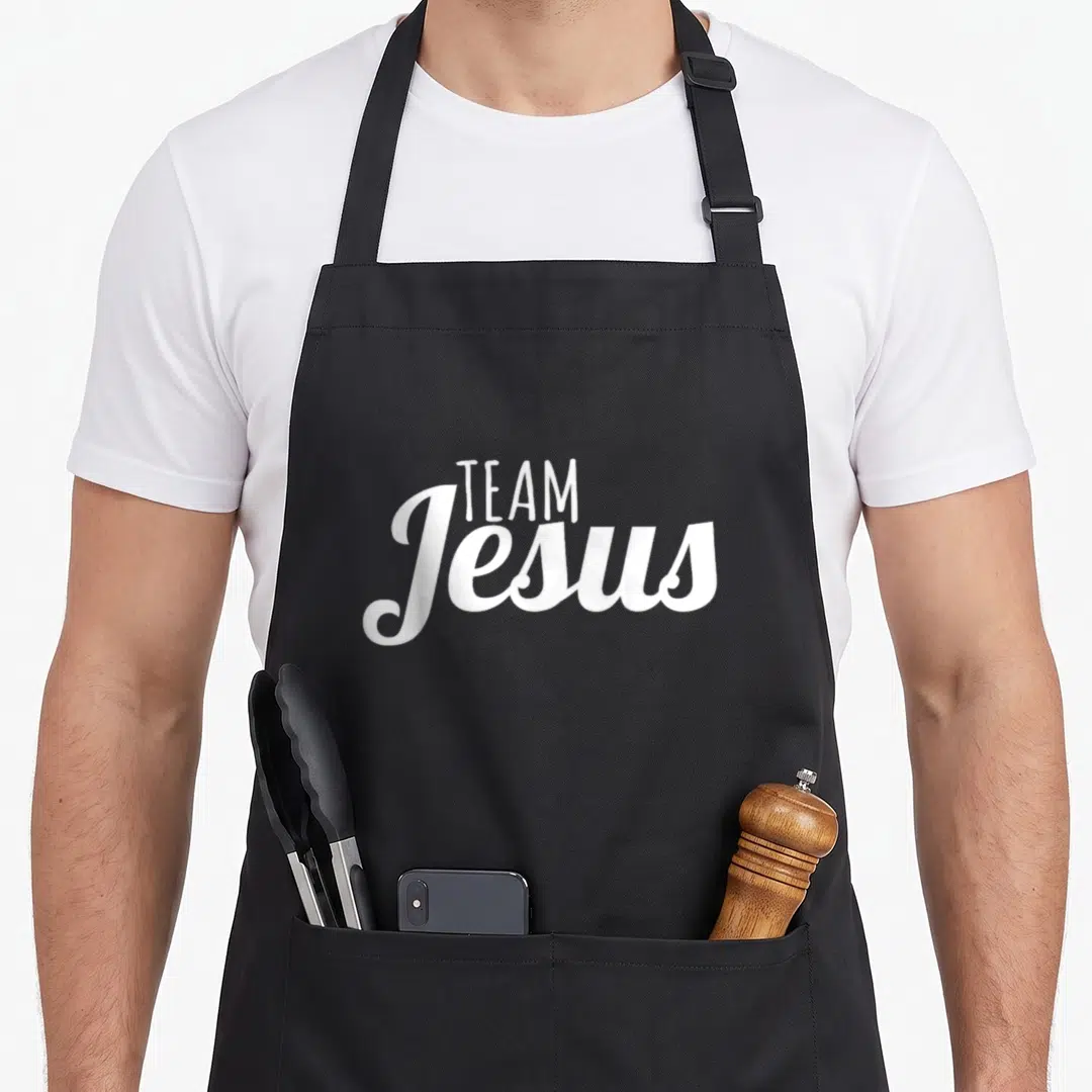 Jesus christianity cross apron - White stacked TEAM Jesus text on black apron background — shown on a black cotton canvas apron against a white background