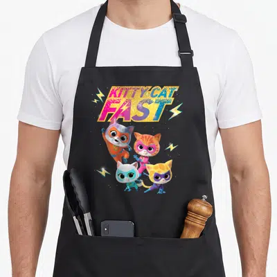Kitty junior apron - Glittery KITTY CAT FAST text above three superhero cats and lightning bolts — shown on a black cotton canvas apron against a white background
