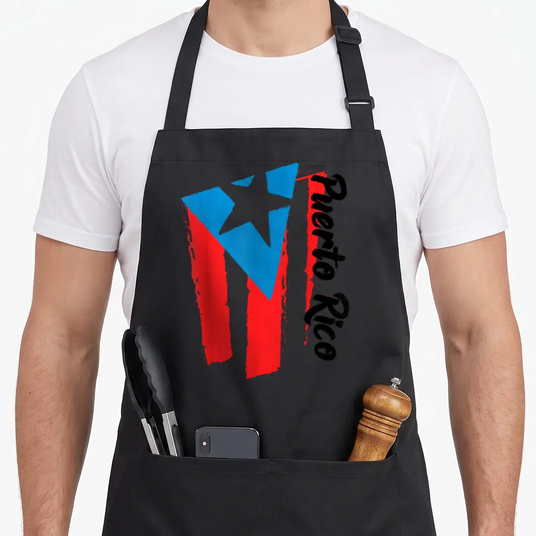 Flag hispanic aprons - Brush stroke Puerto Rico flag in red blue white with vertical black text — shown on a black cotton canvas apron against a white background