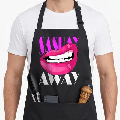 Sashay queen apron - Pink cartoon lips between SASHAY above and AWAY below in white text — shown on a black cotton canvas apron against a white background