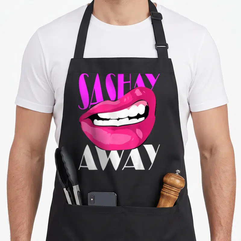 Sashay queen apron - Pink cartoon lips between SASHAY above and AWAY below in white text — shown on a black cotton canvas apron against a white background