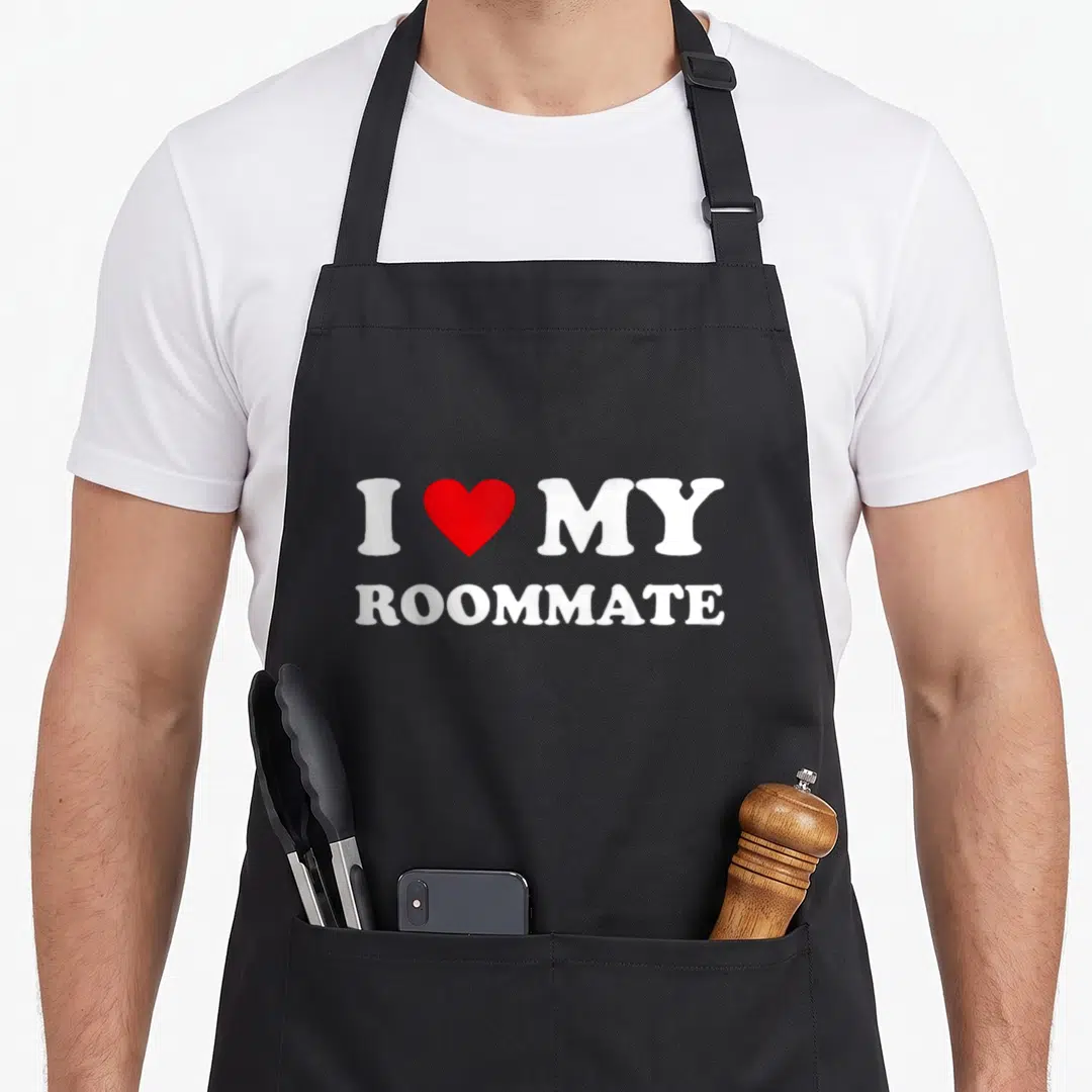 Funny roommate apron - White text I heart MY ROOMMATE with red heart symbol — shown on a black cotton canvas apron against a white background