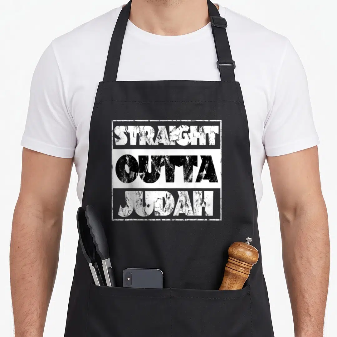 Straight hebrew aprons - Stacked STRAIGHT OUTTA JUDAH text in distressed white and black within rectangular border — shown on a black cotton canvas apron against a white background