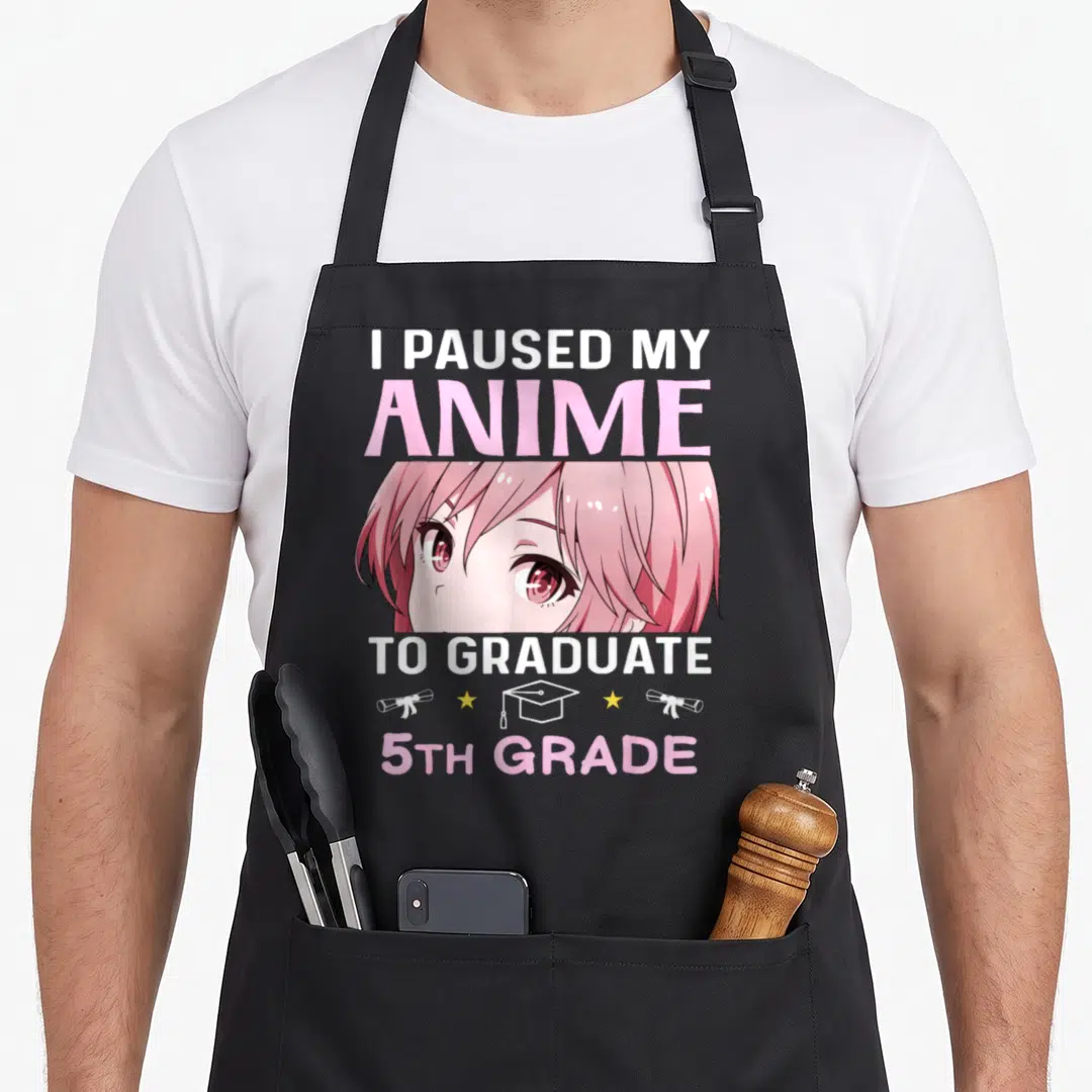 5th anime apron - Anime girl face with I Paused My Anime To Graduate 5th Grade text and graduation icons — shown on a black cotton canvas apron against a white background