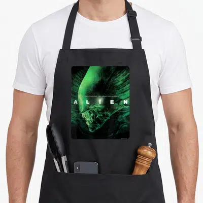 Alien movie poster apron - Green and black alien head with white text IN SPACE NO ONE CAN HEAR YOU SCREAM — shown on a black cotton canvas apron against a white background