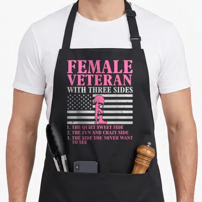 Veteran mother's apron - Pink female veteran silhouette with three sides text on grey background — shown on a black cotton canvas apron against a white background