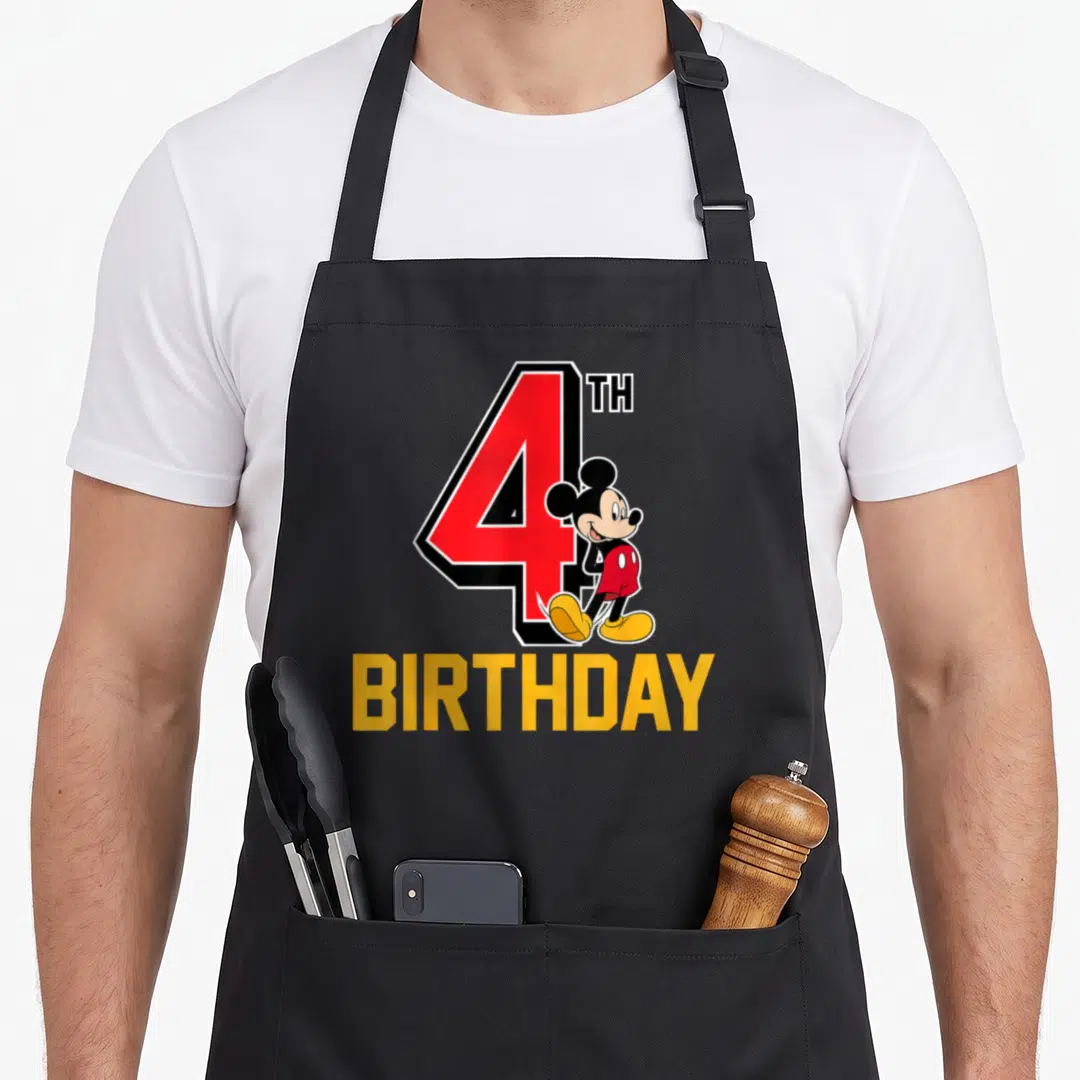 Funny 4th birthday apron - Large red number 4 with standing Mickey Mouse and yellow BIRTHDAY text — shown on a black cotton canvas apron against a white background