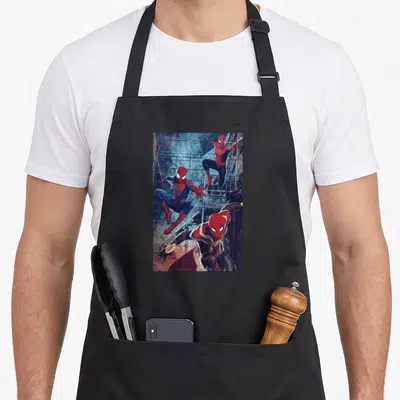 Spider jump apron - Three Spider-Men leaping in red blue grey suits against scaffolding background — shown on a black cotton canvas apron against a white background
