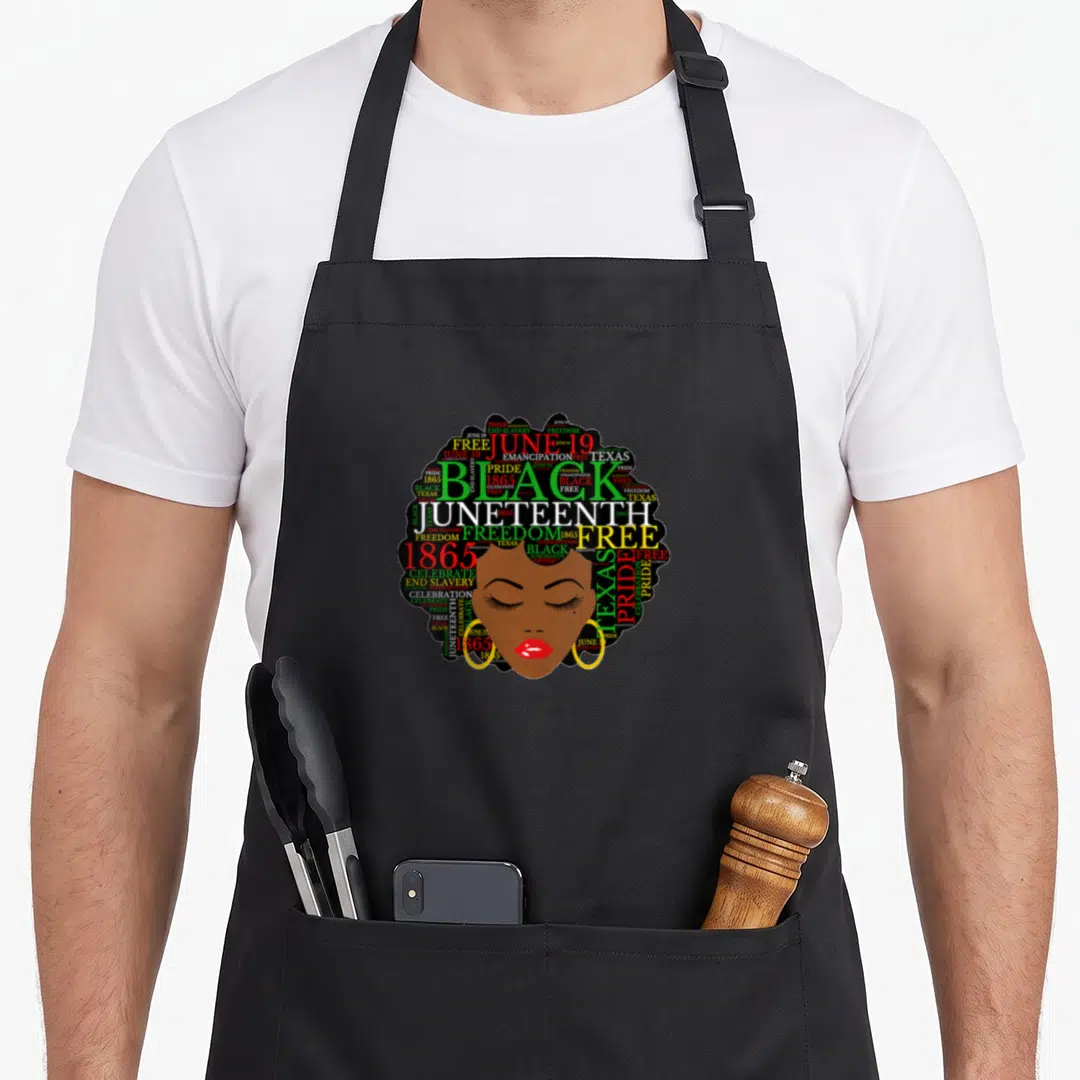 Juneteenth melanin hair apron - Woman's face with Afro composed of Juneteenth, Freedom, 1865, and Emancipation words — shown on a black cotton canvas apron against a white background