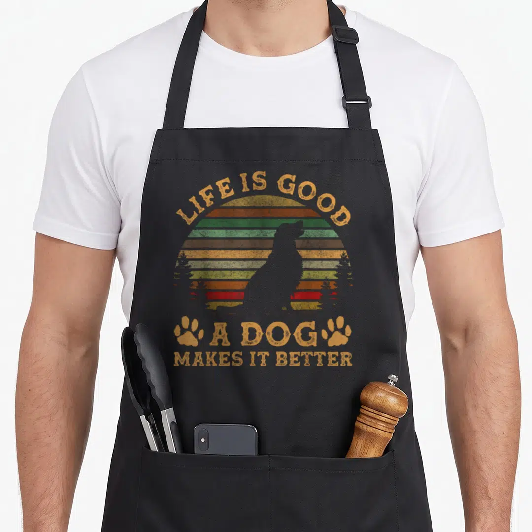 Doe dog apron - Retro striped sun with dog silhouette and text LIFE IS GOOD A DOG MAKES IT BETTER — shown on a black cotton canvas apron against a white background