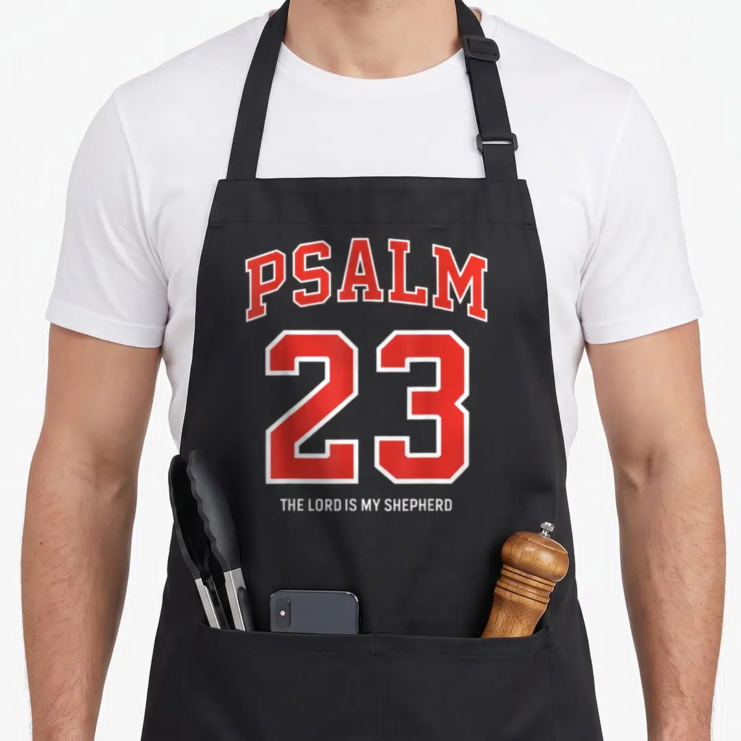 Lord psalm apron - Red and white PSALM 23 text with THE LORD IS MY SHEPHERD caption in varsity font — shown on a black cotton canvas apron against a white background
