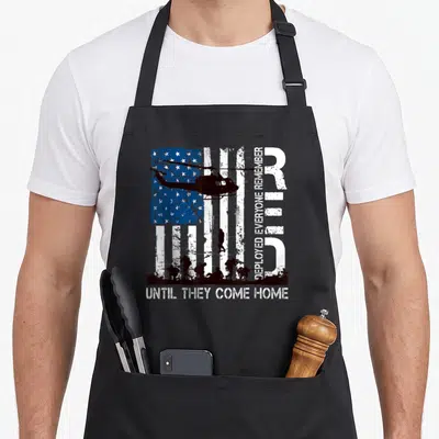 Friday r aprons - Distressed flag helicopter soldier silhouettes DEPLOYED EVERYONE REMEMBER UNTIL THEY COME HOME text — shown on a black cotton canvas apron against a white background