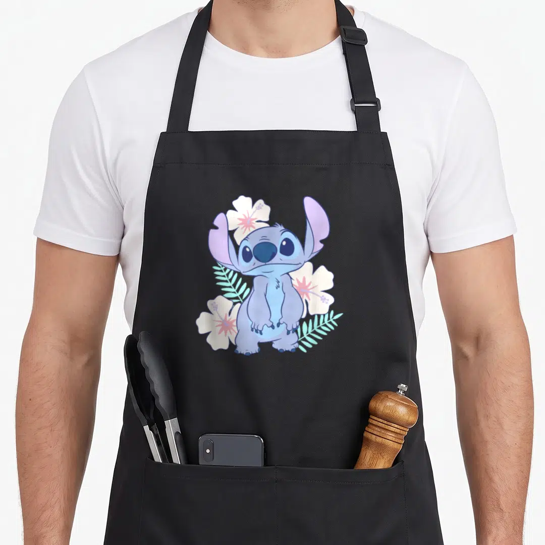 Face hawaiian apron - Blue cartoon character Stitch surrounded by white hibiscus flowers and teal leaves — shown on a black cotton canvas apron against a white background