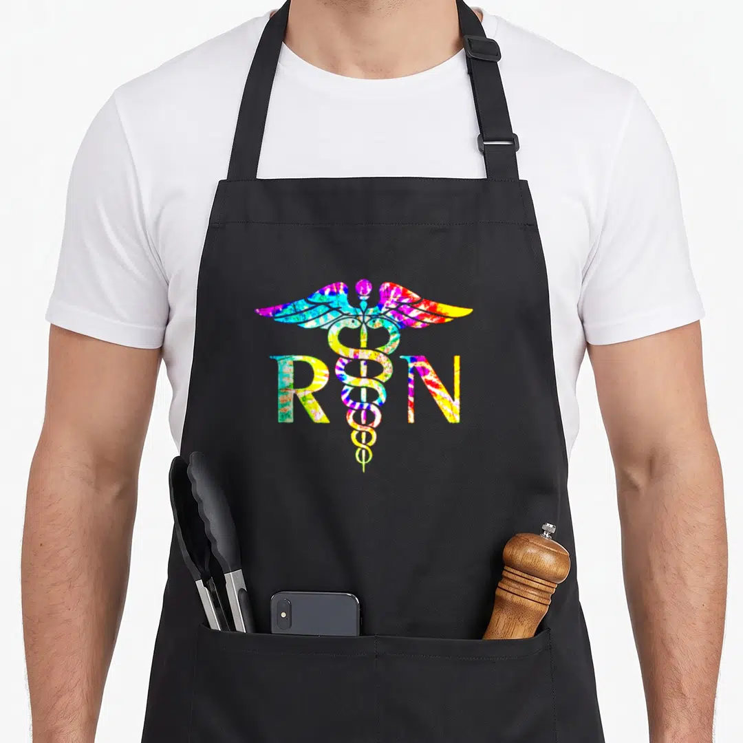Lovely nurse apron - Tie-dye caduceus with RN letters in blue yellow pink green red — shown on a black cotton canvas apron against a white background