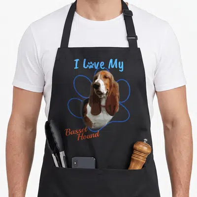 Hound paw dog apron - Basset Hound portrait inside blue paw outline with I Love My text — shown on a black cotton canvas apron against a white background