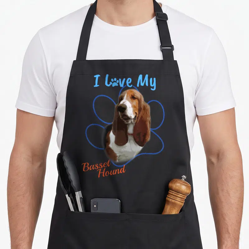 Hound paw dog apron - Basset Hound portrait inside blue paw outline with I Love My text — shown on a black cotton canvas apron against a white background
