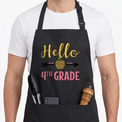 Hello leopard apron - Hello 4th Grade text with leopard print apple and arrow graphic — shown on a black cotton canvas apron against a white background