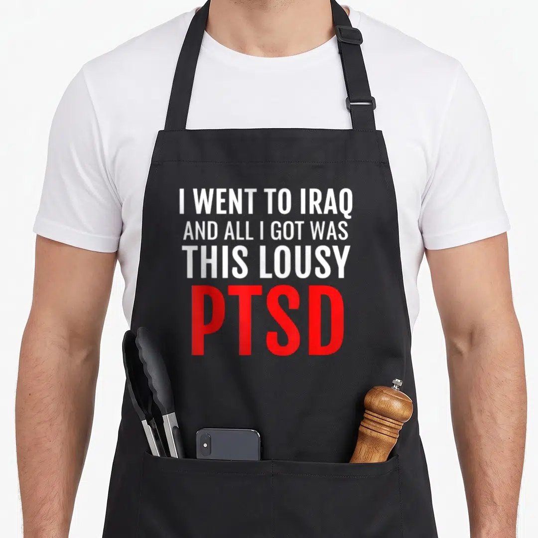 Iraq female veteran apron - White and red stacked text reading I WENT TO IRAQ AND ALL I GOT WAS THIS LOUSY PTSD — shown on a black cotton canvas apron against a white background