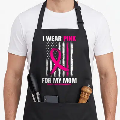 Flag breast cancer awareness aprons - Pink ribbon over distressed white and pink US flag with text I Wear Pink For My — shown on a black cotton canvas apron against a white background