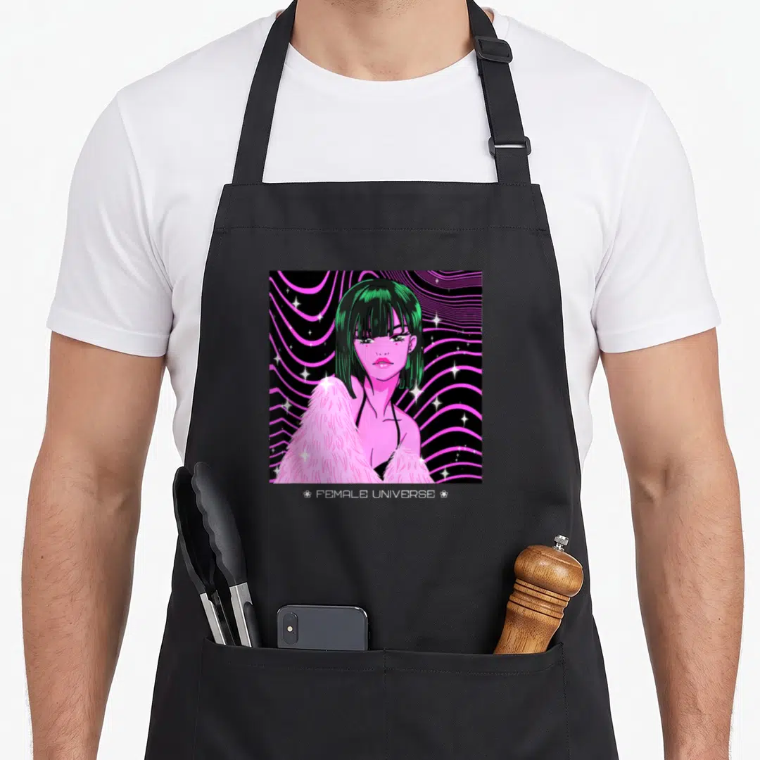 Feminist anime apron - Green hair woman pink fur coat FEMALE UNIVERSE text wavy lines stars — shown on a black cotton canvas apron against a white background