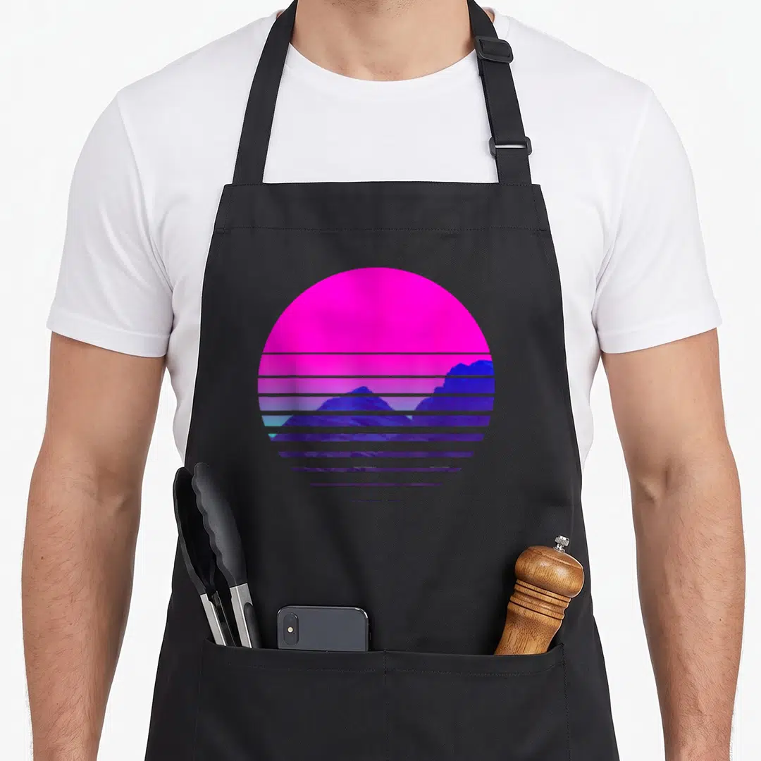 Vaporwave mountain man apron - Pink sun behind blue and purple mountains sliced by horizontal lines in retro style — shown on a black cotton canvas apron against a white background