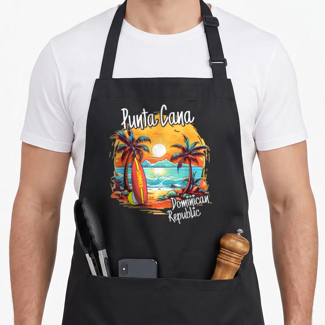 Dominican family aprons - Punta Cana beach scene with palm trees, summer surfboard, and Dominican Republic text — shown on a black cotton canvas apron against a white background