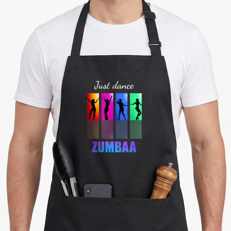 Dancing ba apron - Just dance text above four black dancer silhouettes in orange pink blue green rectangles with Zumbaa — shown on a black cotton canvas apron against a white background
