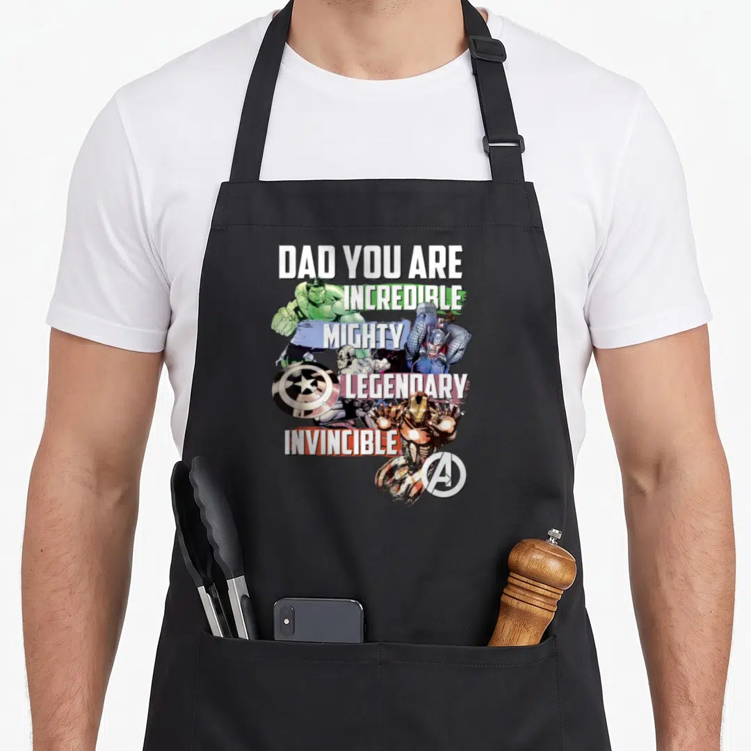 Vintage incredible father day apron - Stacked text Dad You Are Incredible Mighty Legendary Invincible with Avengers — shown on a black cotton canvas apron against a white background