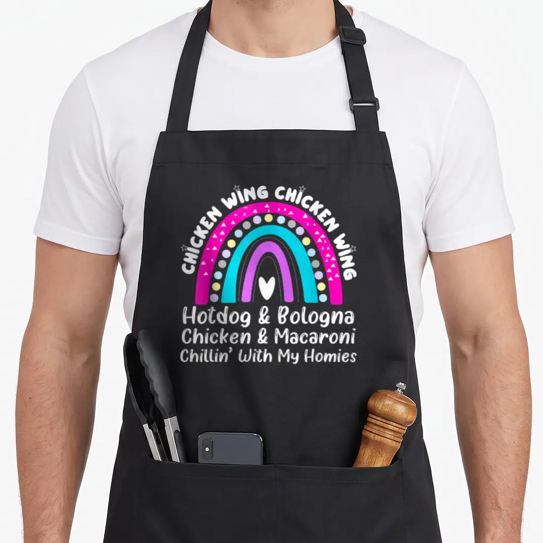 Song hot dog apron - Rainbow graphic with white text listing chicken wings, hotdogs, bologna, and macaroni lyrics — shown on a black cotton canvas apron against a white background