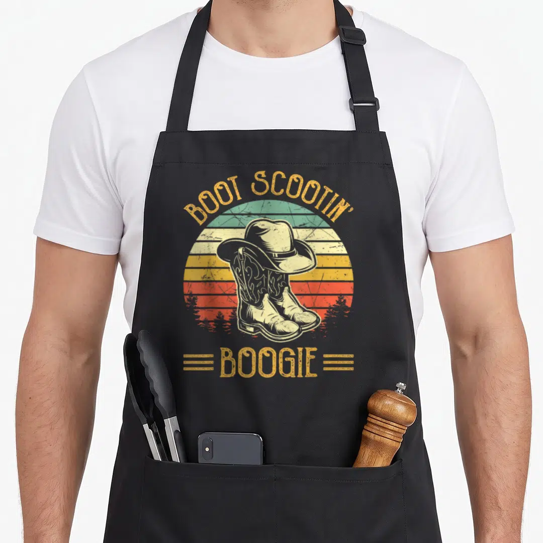 Boot southern aprons - Retro striped sun with cowboy hat on boots and BOOT SCOOTIN' BOOGIE text — shown on a black cotton canvas apron against a white background