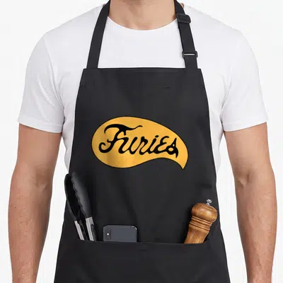Fury warrior apron - Black script reading Furies inside a yellow organic oval with a black border — shown on a black cotton canvas apron against a white background