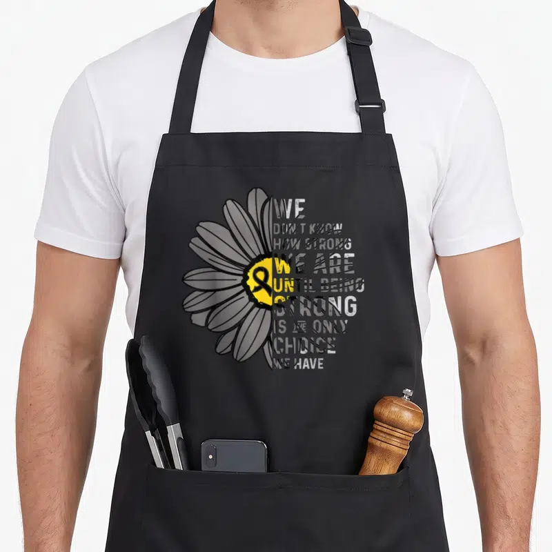Strong ribbon apron - Split daisy with stacked text and yellow center ribbon on black background — shown on a black cotton canvas apron against a white background