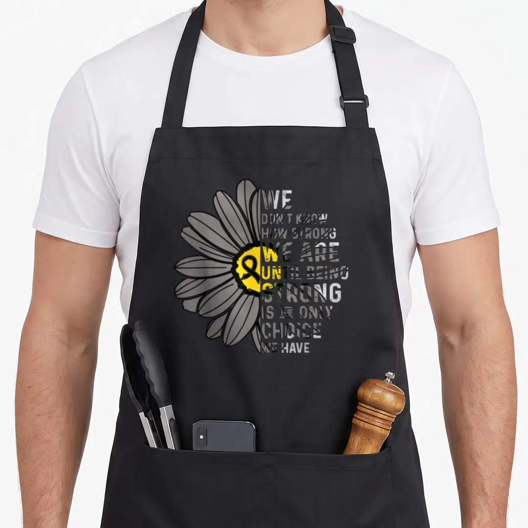 Strong ribbon apron - Split daisy with stacked text and yellow center ribbon on black background — shown on a black cotton canvas apron against a white background