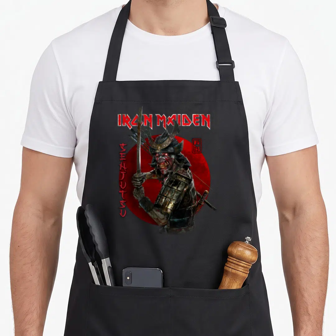Senjutsu eddie camping apron - Zombie samurai holding sword in front of red circle with IRON MAIDEN text and vertical — shown on a black cotton canvas apron against a white background