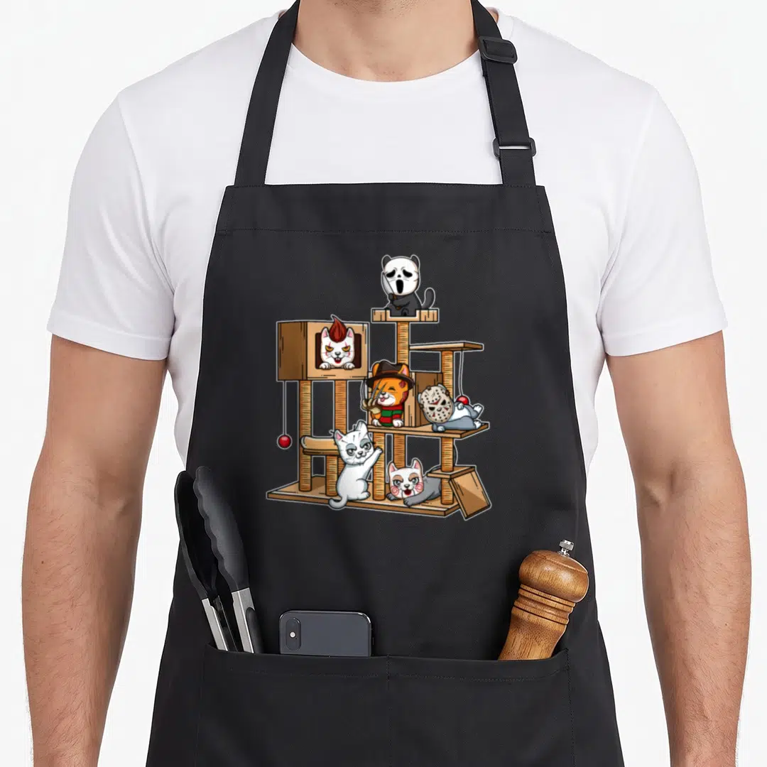 Movie cute cat apron - Five cartoon cats dressed as horror villains on a brown cat tree with a red hanging ball — shown on a black cotton canvas apron against a white background
