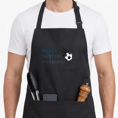 Sterling falcon lover apron - Stacked blue text 'The MAN The MYTH THE LEGEND Scott Sterling' beside a moving soccer ball — shown on a black cotton canvas apron against a white background