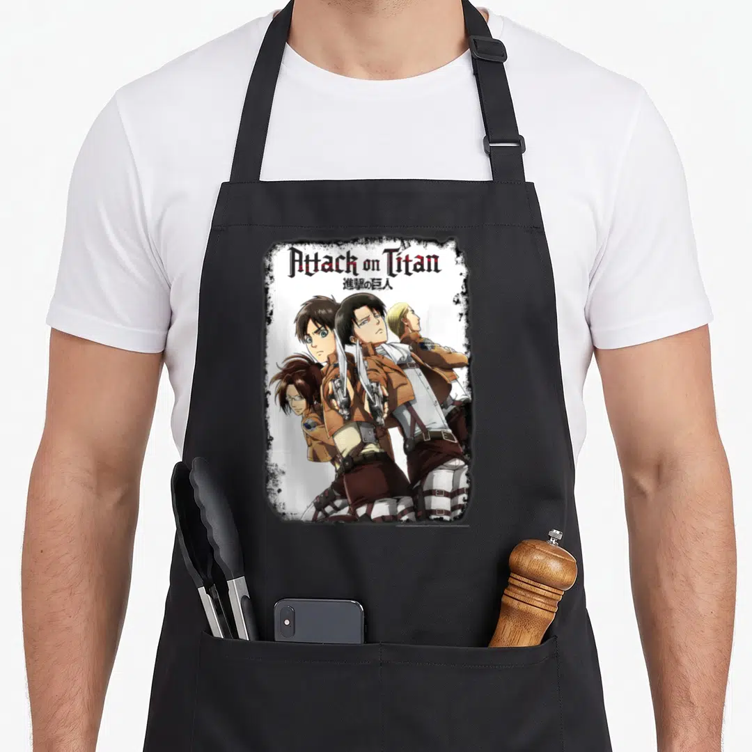 Portrait anime apron - Attack on Titan text, Japanese chars, four characters, two swords, brown white red black — shown on a black cotton canvas apron against a white background