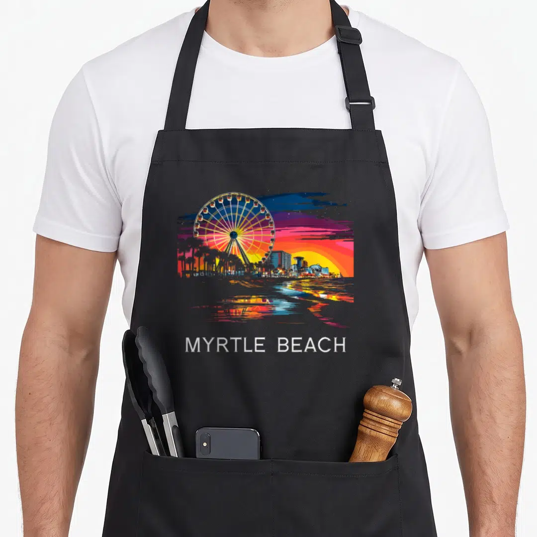 Skywheel myrtle beach apron - Retro Ferris wheel cityscape with MYRTLE BEACH text in orange blue purple white — shown on a black cotton canvas apron against a white background