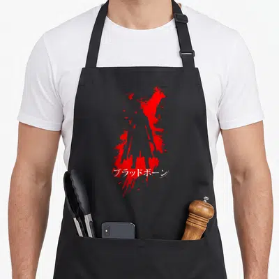 Bloodborne video game apron - Red silhouette of a figure surrounded by splatter with white Japanese text across — shown on a black cotton canvas apron against a white background