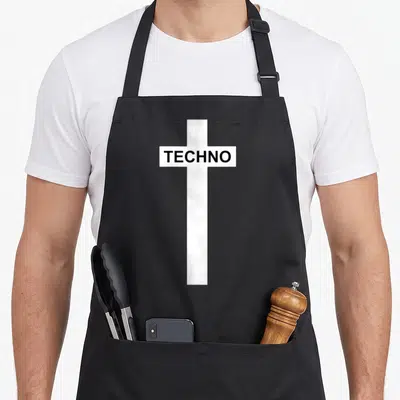 Berghain techno apron - White cross with TECHNO text in black block letters — shown on a black cotton canvas apron against a white background