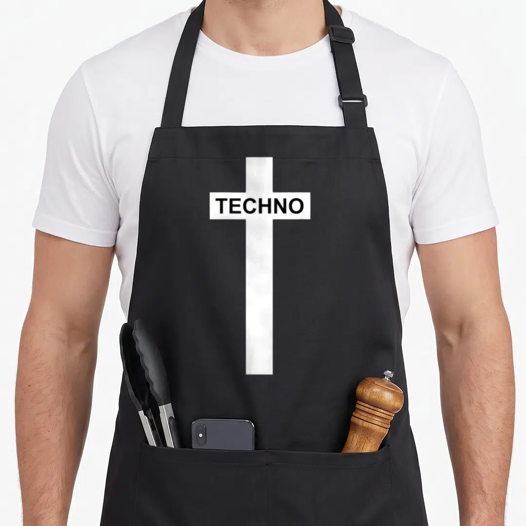 Berghain techno apron - White cross with TECHNO text in black block letters — shown on a black cotton canvas apron against a white background