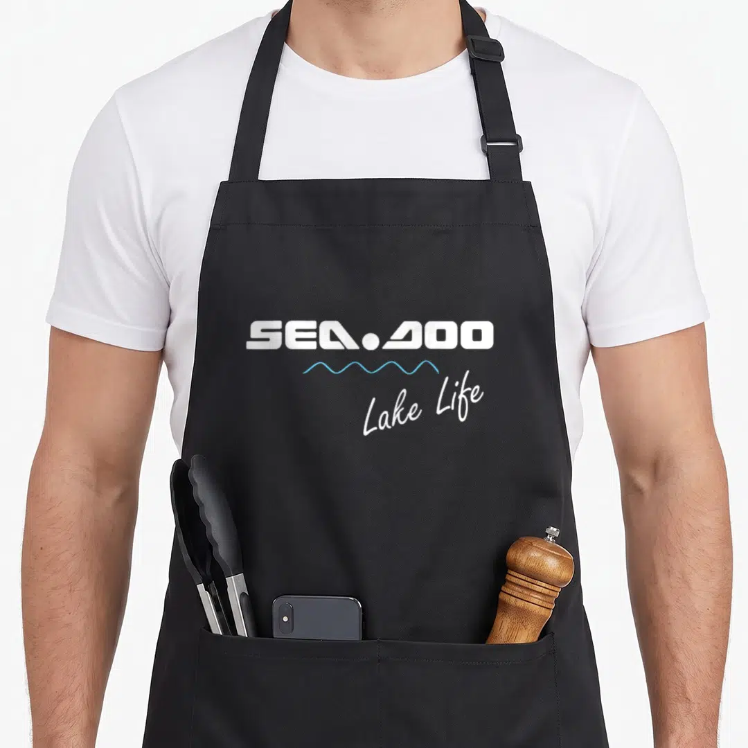 Wave summer life apron - SEA-DOO text above blue wave line and Lake Life script — shown on a black cotton canvas apron against a white background