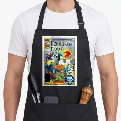 Exclusive cover apron - Fantastic Four comic cover with skull cameo logo and $1.00 US price tag in blue red yellow — shown on a black cotton canvas apron against a white background