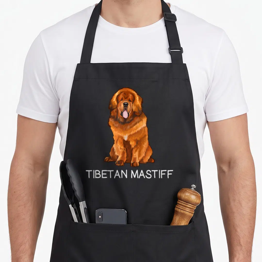 Tibetan cooking with dog apron - Cartoon brown and white Tibetan Mastiff sitting above white TIBETAN MASTIFF text — shown on a black cotton canvas apron against a white background