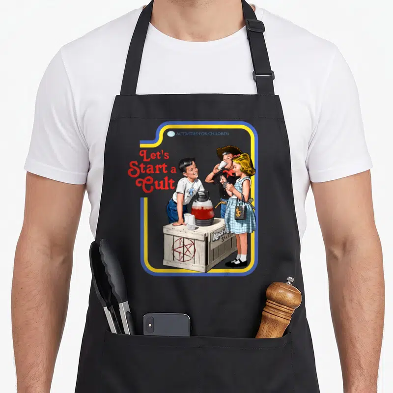 Cult round neck apron - Three children at wooden crate with red pentagram, blue yellow border, retro style — shown on a black cotton canvas apron against a white background