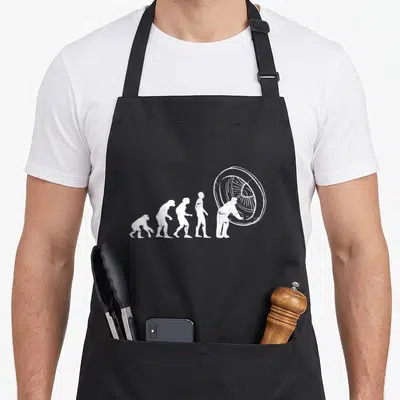 Maintenance airplane apron - White line art of five evolutionary figures culminating in a person holding a jet engine — shown on a black cotton canvas apron against a white background