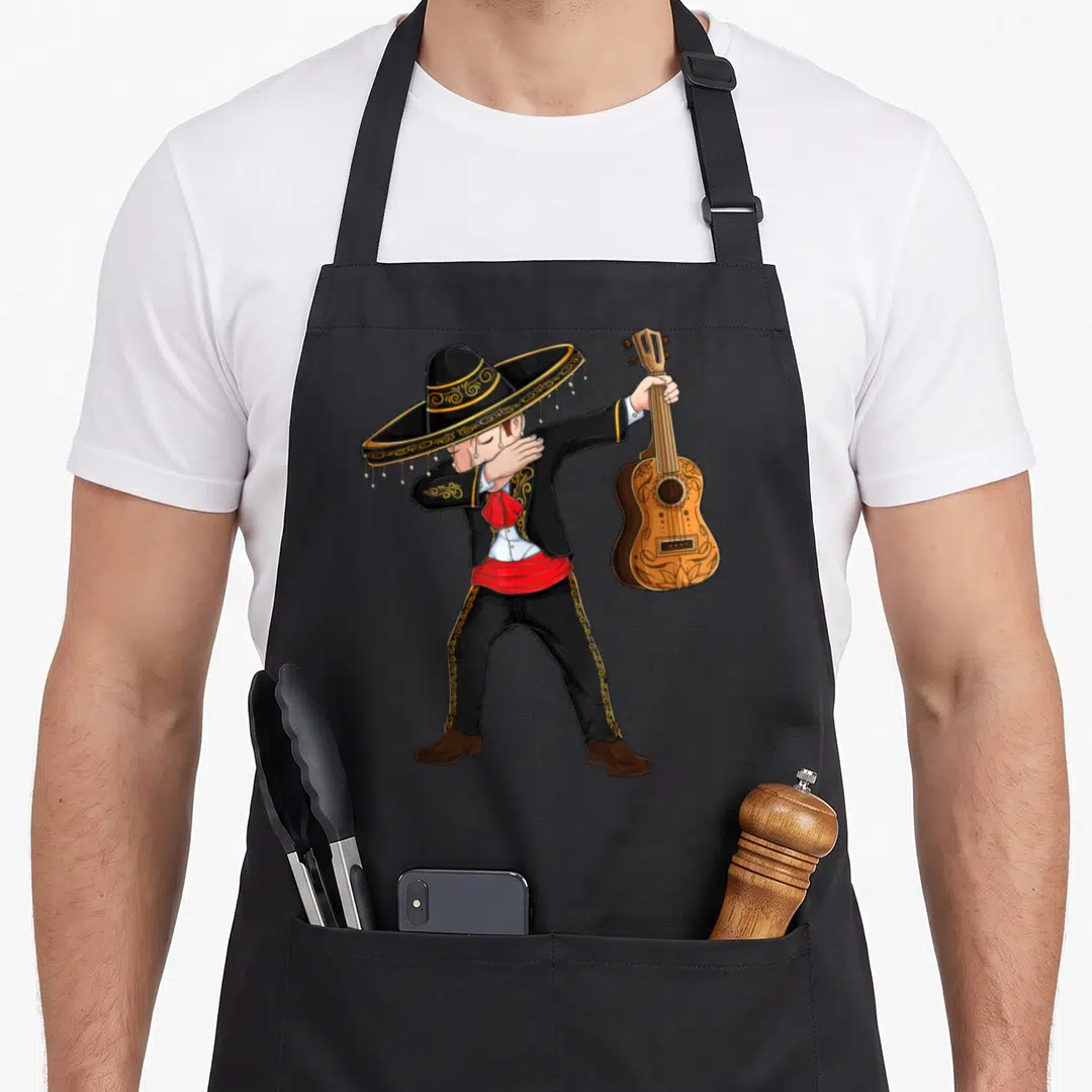 Dab mariachi mexican apron - Cartoon mariachi in black and gold suit dabbing while holding a brown guitar — shown on a black cotton canvas apron against a white background