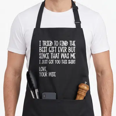 Tried husband apron - White text reading I Tried to Find the Best Gift Ever but since that was me I just got you this — shown on a black cotton canvas apron against a white background